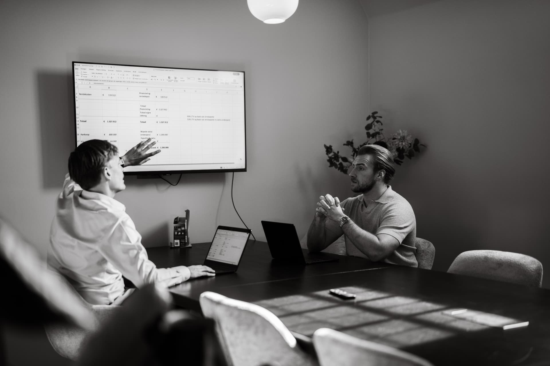 Toine en Jelle bespreken een financieringsdossier aan de vergadertafel